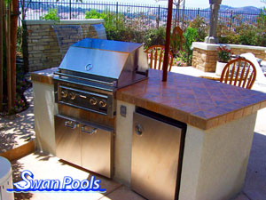 Small arc BBQ with tile top, stucco sides, a built in refridgerator, and serving shelf.  Click on image for a larger picture.