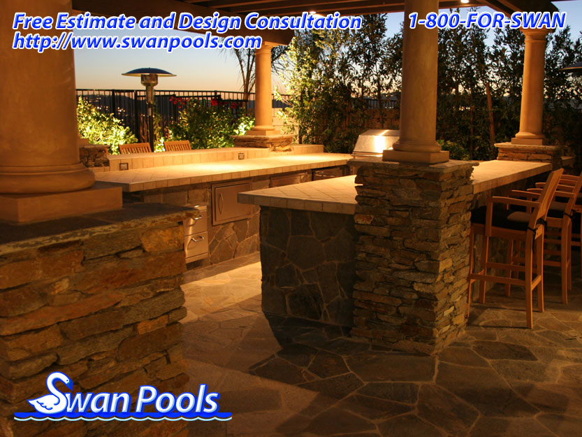 Custom U-shape, outdoor kitchen barbeque with tile top, ledger stone veneer, and custom overhead patio cover.