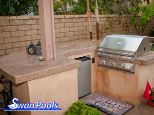 Small arc BBQ with tile top, stucco sides, and integrated into overhead patio cover.  Click on image for a larger picture.